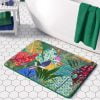 A kids' bath mat featuring a colorful jungle theme with a colorful bird.