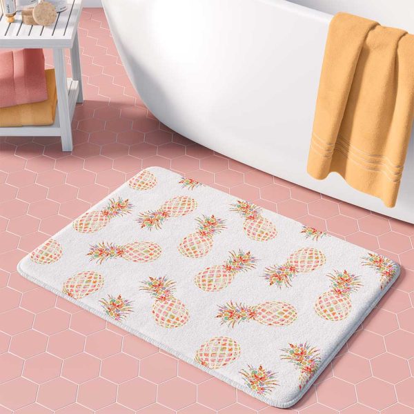 White bath mat with tropical pink and orange pineapple pattern.