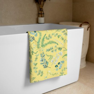 Yellow bath towel with leafy green floral pattern