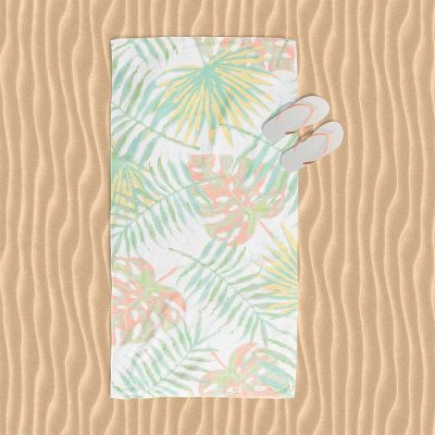 Beach towel with abstract tropical apricot palm leaves pattern.